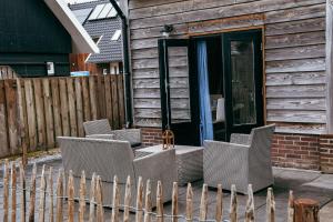 a group of chairs on a patio in front of a house at BenB de Buutnboer in Rouveen