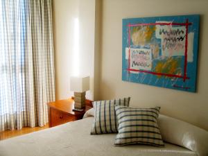 ein Schlafzimmer mit einem Bett und einem Gemälde an der Wand in der Unterkunft URDINETXE in Luyando