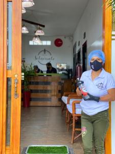 een vrouw met een masker voor een restaurant bij Hotel Sotavento in Montañita