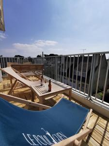 a patio with tables and chairs on a balcony at Le Kerdun Bord de mer tout à pied in Le Pouliguen