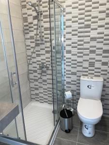 a bathroom with a toilet and a glass shower at La Veranda Hotel in Larnaca