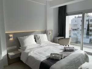 a bedroom with a large white bed and a window at La Veranda Hotel in Larnaca
