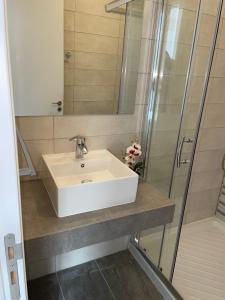a bathroom with a white sink and a shower at La Veranda Hotel in Larnaca