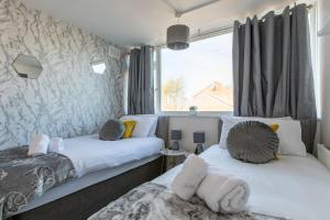- 2 lits dans une chambre avec fenêtre dans l'établissement Stylish House & Work and Leisure inc FREE Parking & BHX Airport, à Coventry