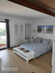a white bedroom with a bed and a table at Fabulous Sea view Studio near old town Albufeira in Albufeira