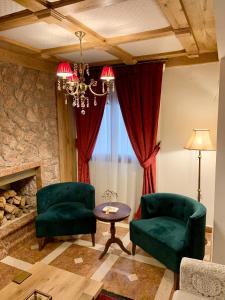 a living room with two green chairs and a fireplace at Xenonas Iresioni in Arachova