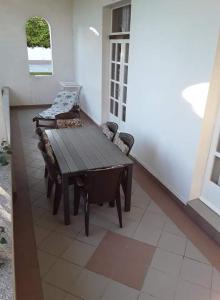 uma mesa de madeira e cadeiras num quarto com uma janela em Rab Apartments Žic em Kampor