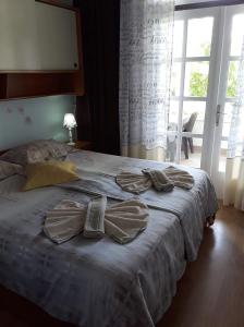 a bed with a pair of shoes on top of it at Rab Apartments Žic in Kampor