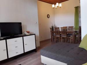 a living room with a television and a dining room at Rab Apartments Žic in Kampor