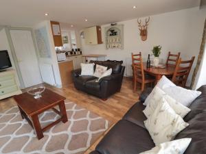 uma sala de estar com um sofá e uma mesa em Chillingham Cottage em Belford