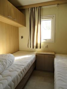 a bedroom with two beds and a window at Chalet 3 in Meliskerke