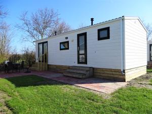 a white house with a porch and a patio at Chalet 3 in Meliskerke