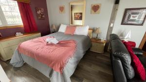 - une chambre avec un lit et une couverture rouge dans l'établissement Auberge et Chalets sur le Lac, à Lac-Mégantic