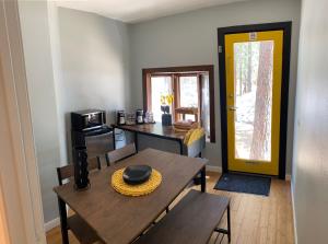 a dining room with a table and a yellow door at The Mammoth Inn in Mammoth Lakes