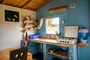 a small kitchen with a sink and a stove at Quinta Los Duendes in Tanicuchí
