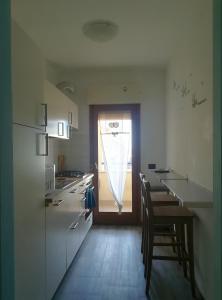 Romanina Appartamento Giuland في روما: مطبخ مع طاولة وكراسي ونافذة