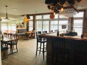 a restaurant with a bar with chairs and a table at Auberge et Chalets sur le Lac in Lac-Mégantic