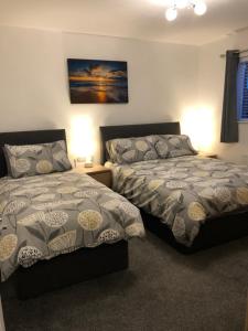 Giường trong phòng chung tại Hopefield Premium Holiday Home Portrush Sleeps 10 4 bedrooms