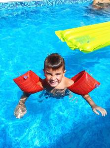 um menino na água em uma piscina em Apartments Maljevic em Bar