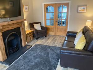 sala de estar con sofá y chimenea con TV en Hopefield Premium Holiday Home Portrush Sleeps 10 4 bedrooms en Portrush