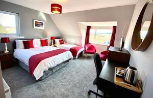 a bedroom with two beds and a desk and a window at Blacksmith holiday cottage near Portree in central Skye in Portree