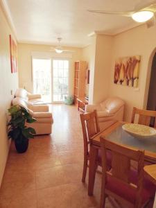- un salon avec une table et un canapé dans l'établissement Nice apartment with spacious terrass and rooftop, à Los Alcázares