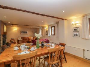a kitchen and living room with a wooden table and chairs at The Old Barn in Hereford