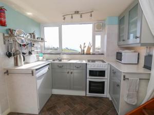 a kitchen with white appliances and a window at The Grain Store in Abersoch