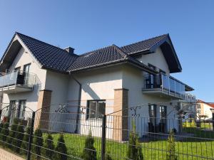 a house with a fence in front of it at Passo Rowy in Rowy