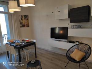 ein Wohnzimmer mit einem Tisch und einem TV an der Wand in der Unterkunft Pretty and quiet top floor 2 bedroom flat in the port area of Nice in Nizza