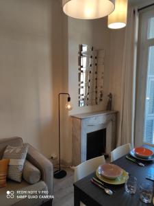 ein Wohnzimmer mit einem Tisch und einem Kamin in der Unterkunft Pretty and quiet top floor 2 bedroom flat in the port area of Nice in Nizza