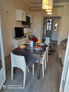 uma sala de jantar e sala de estar com mesa e cadeiras em Pretty and quiet top floor 2 bedroom flat in the port area of Nice em Nice