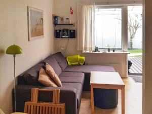 a living room with a purple couch and a table at 4 person holiday home in Nex in Strandby Gårde