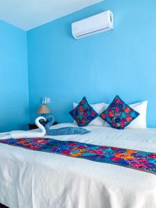a blue bedroom with a bed with a swan on it at Casa Biulú in Zipolite