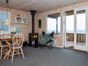 オーベンローにある4 person holiday home in Aabenraaのリビングルーム(暖炉、テーブル、椅子付)