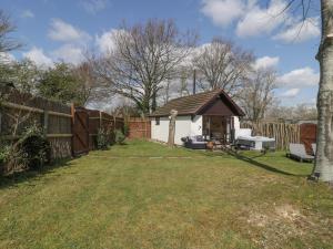 a backyard with a gazebo and a fence at Pheasant Lodge at Chapel Lodges in Wimborne Minster