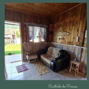 sala de estar con sofá de cuero y ventana en Cantinho do paraíso en Gamboa