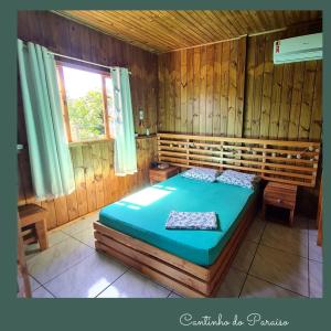 um quarto com uma cama num quarto de madeira em Cantinho do paraíso em Gamboa