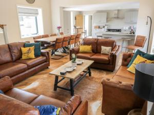 a living room with brown leather couches and a table at Pheasant's Roost in Hull