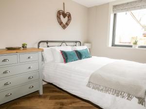 a white bedroom with a bed and a dresser at Owl's Hoot in Hull