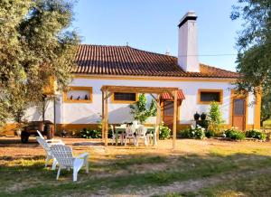 a house with a table and chairs in front of it at Casas Herdade do Convento da Serra in Almeirim
