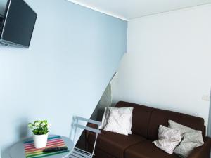 ein Wohnzimmer mit einem braunen Sofa und einem Tisch in der Unterkunft Saint Georges - ParisSmile in Villeneuve-Saint-Georges