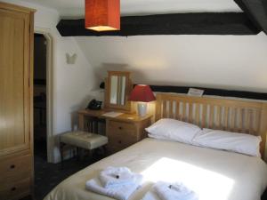 Bredwardine的住宿－紅獅賓館，一间卧室配有带毛巾的床