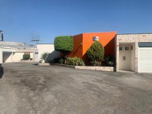 a house with an orange roof and a driveway at Motel Xcaret in Guadalajara