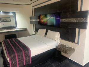 pokój hotelowy z łóżkiem i telewizorem na ścianie w obiekcie Motel Xcaret w mieście Guadalajara