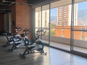a row of exercise bikes in a room with windows at APTO AMOBLADO 77 mt2 in Itagüí
