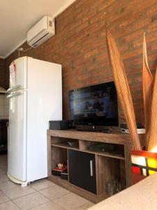 eine Küche mit einem weißen Kühlschrank und einem TV in der Unterkunft Cabaña Bello Horizonte, 3 5 3 5 0 8 5 9 0 6 ,dos dormitorios con cochera privada doble, asador y parque in Villa María
