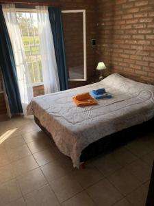 een slaapkamer met een bed met handdoeken erop bij Cabaña Bello Horizonte, 3 5 3 5 0 8 5 9 0 6 ,dos dormitorios con cochera privada doble, asador y parque in Villa María