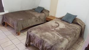 two beds sitting in a room with at Departamento Zona Dorada Mazatlán 6 in Mazatlán