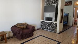 a living room with a chair and a flat screen tv at Departamento Zona Dorada Mazatlán 6 in Mazatlán